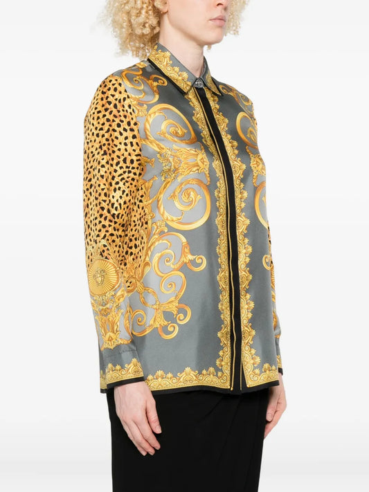 Female model wearing a cheetah and barocco print silk blouse with gold and black design on a white background.