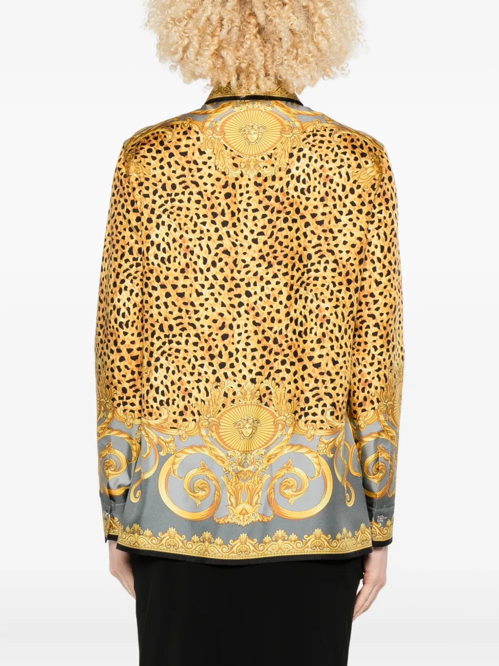 emale model wearing a cheetah and barocco print silk blouse with gold and black design on a white background.