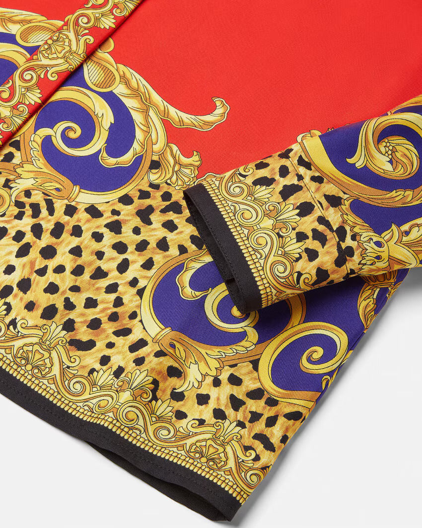 Red silk shirt with gold and purple baroque print on a white background.