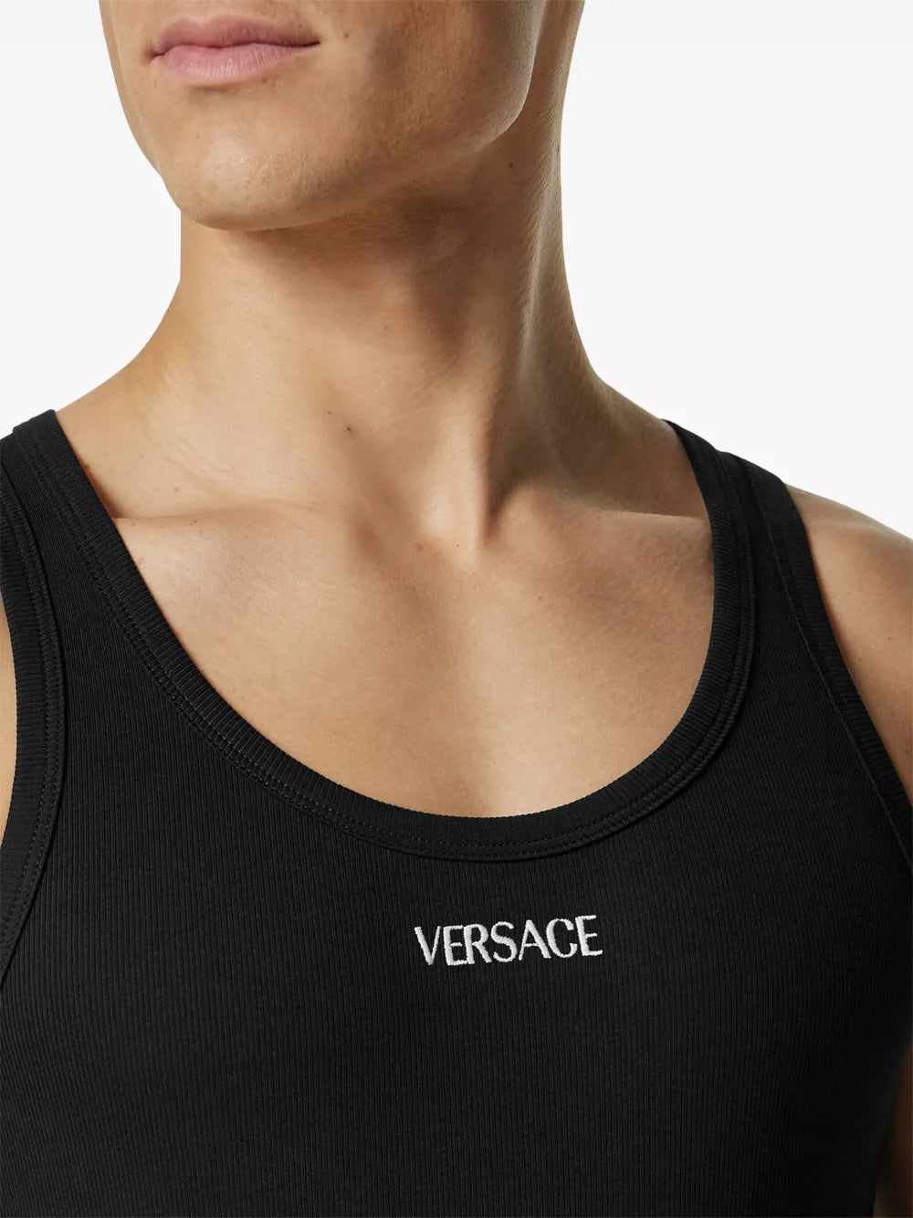 Black Versace tank top worn by a male model on a white background