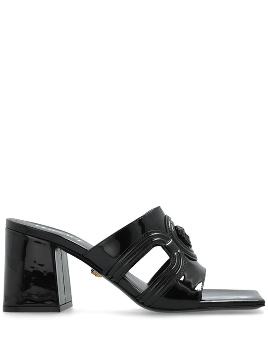Black patent mule heel with a Medusa '95 design on a white background.