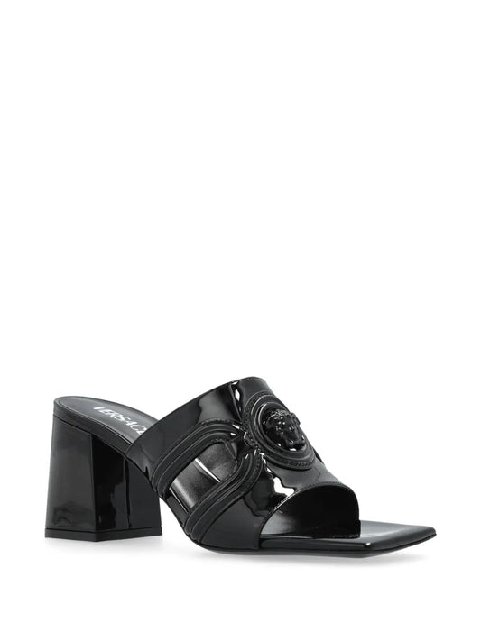 Black patent mule sandal with a VERSACE Medusa '95 design on a white background.