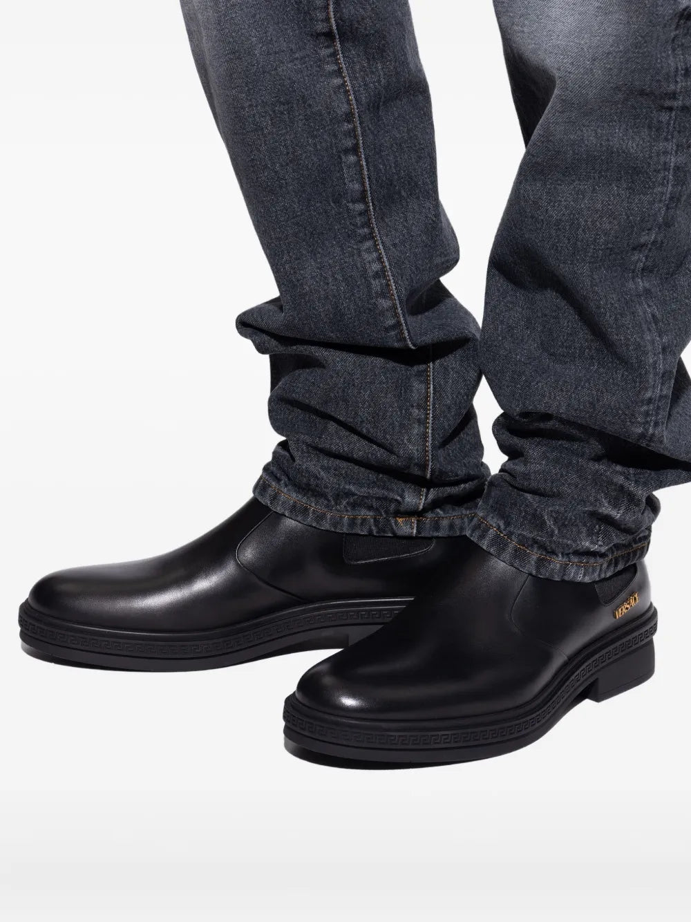 Black Versace Chelsea boots worn with jeans.