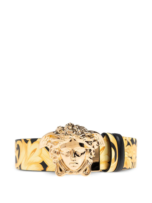 Gold buckle belt with Medusa head design on a white background.