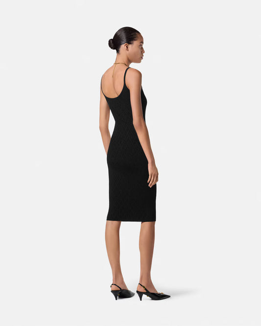 Woman wearing a black knit dress on a white background.