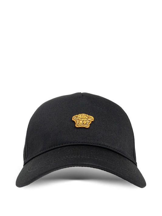 Black cap with a gold emblem on a white background.