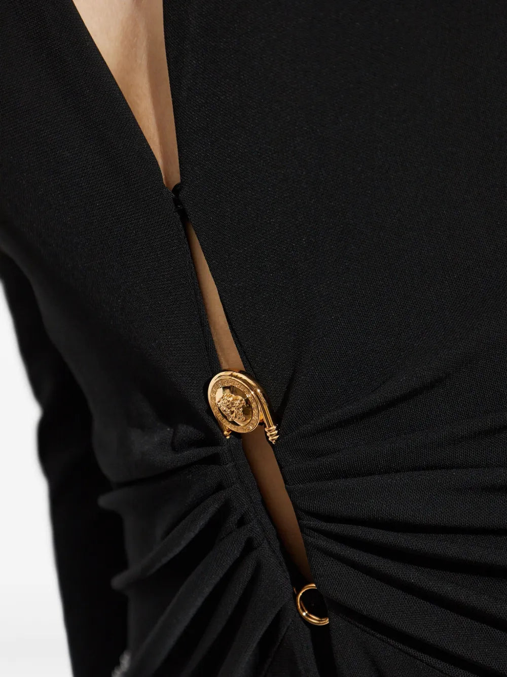 Black bodysuit with gold safety pin on a white background.