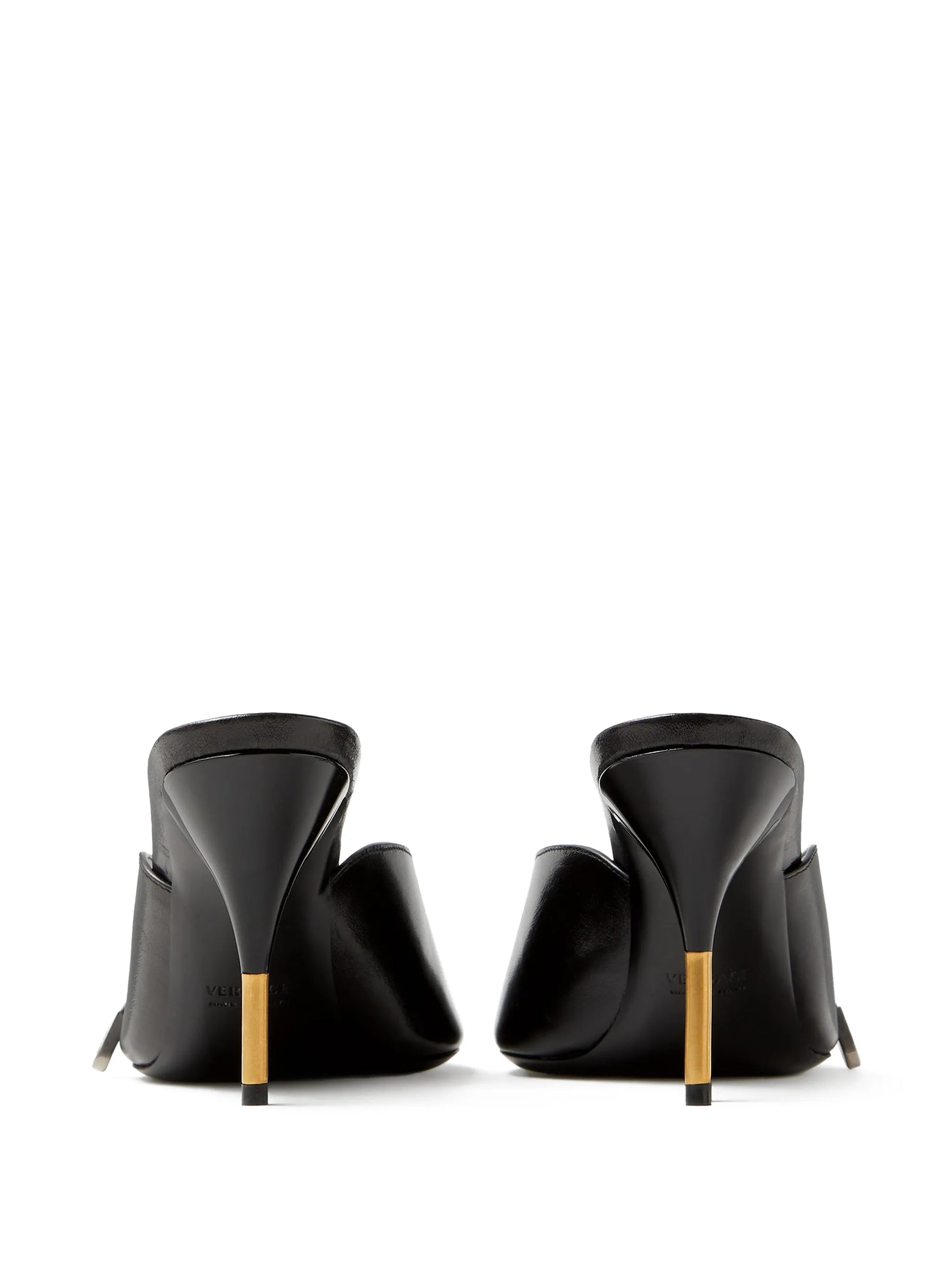Black high-heeled Versace mules with gold accents on a white background