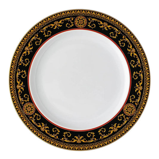A round white Versace china plate with an ornate black and gold baroque-style border, featuring a thin red inner ring.